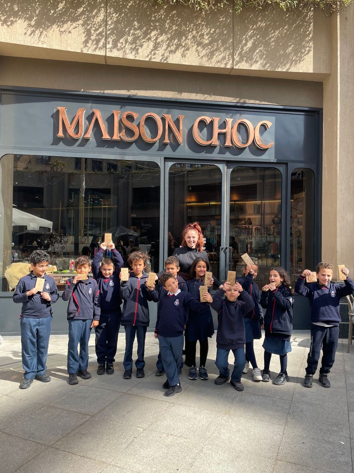 Kids with the chocolate bars they made, outside Maison Choc